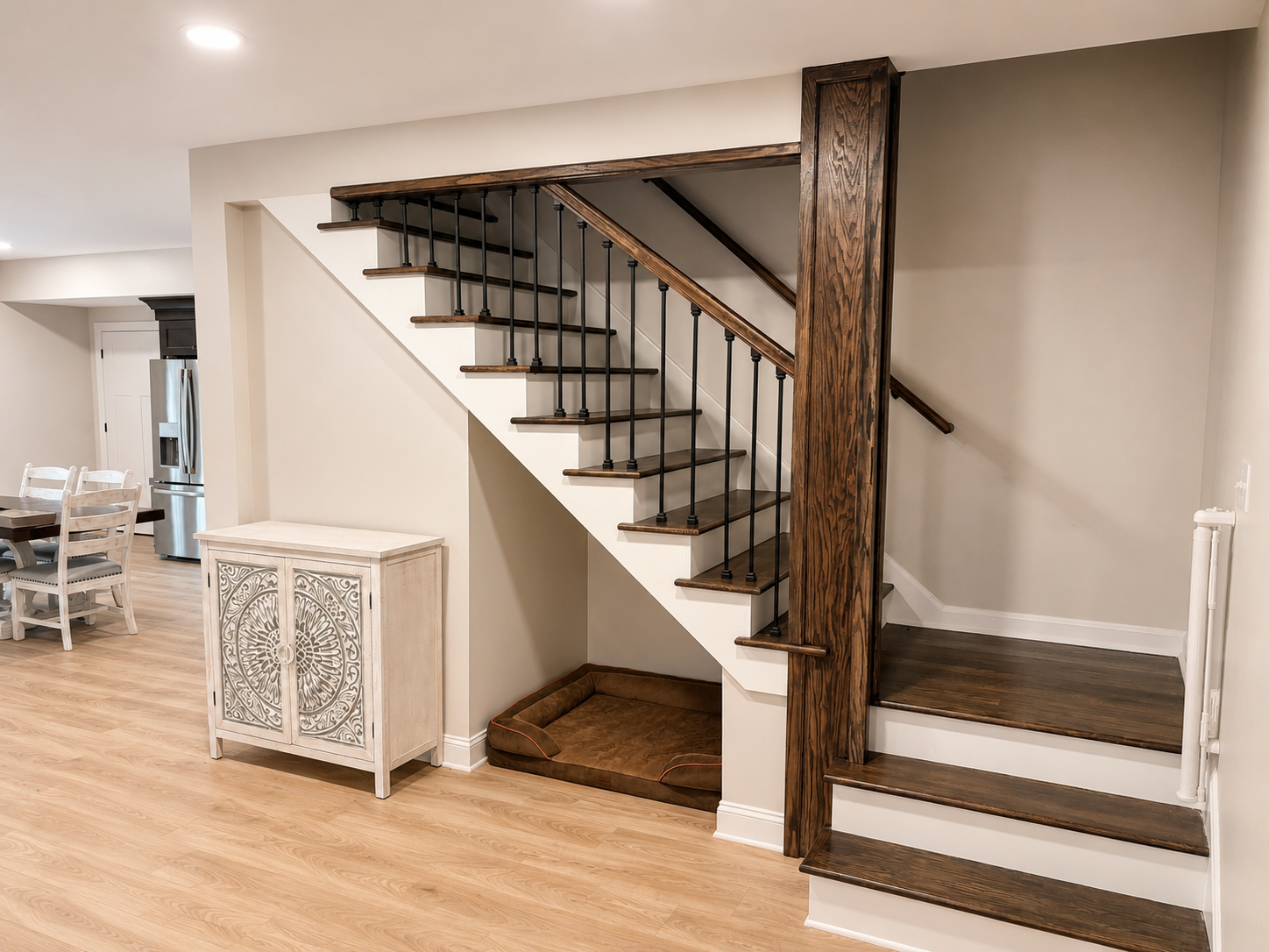 Basement Build Out — staircase with dark stained wood treads, black iron balusters, and open view to kitchen by Luxe Built Louisville KY