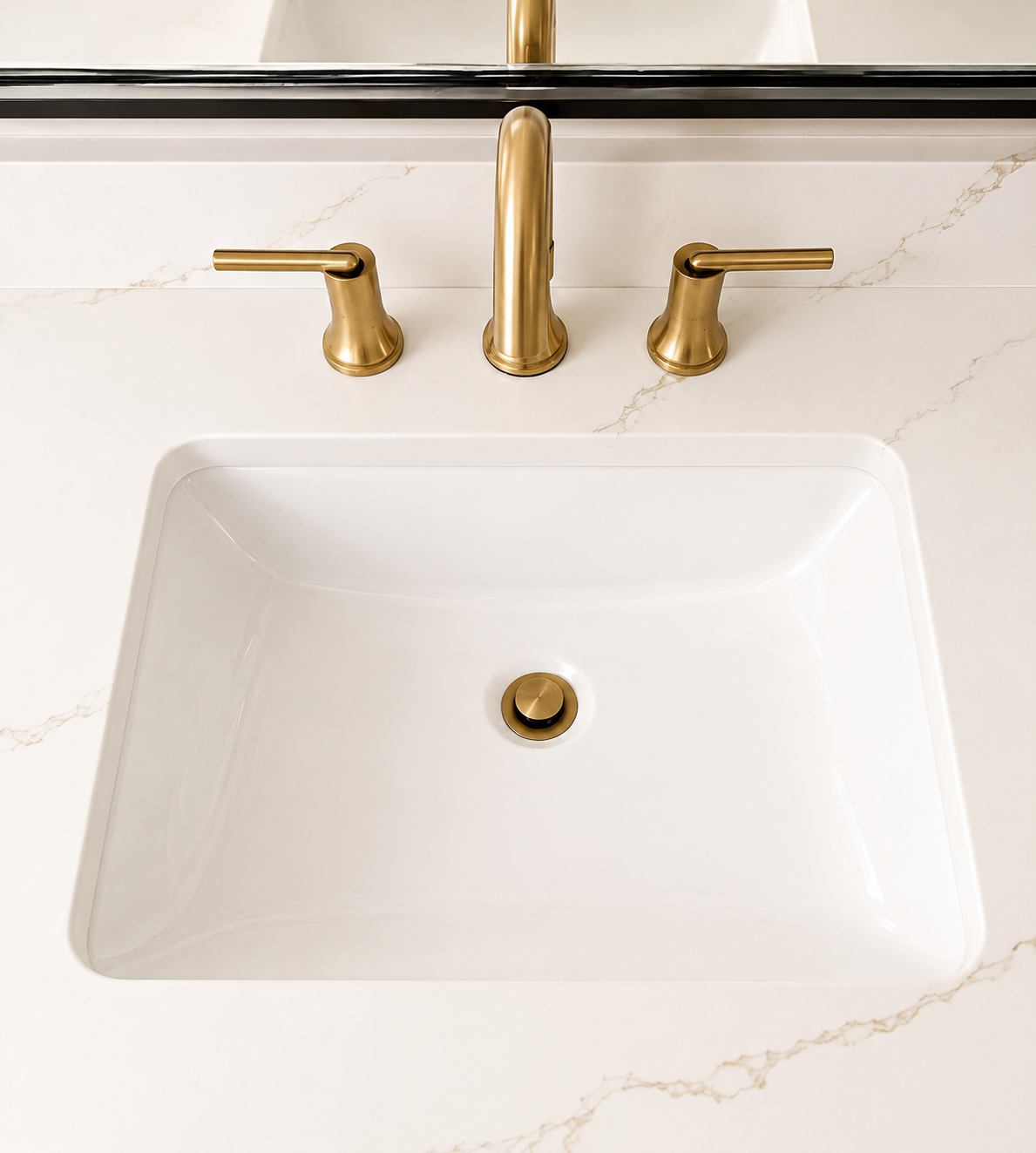 Elegant Bathroom — vanity detail with brass fixtures and stone countertop by Luxe Built Louisville KY