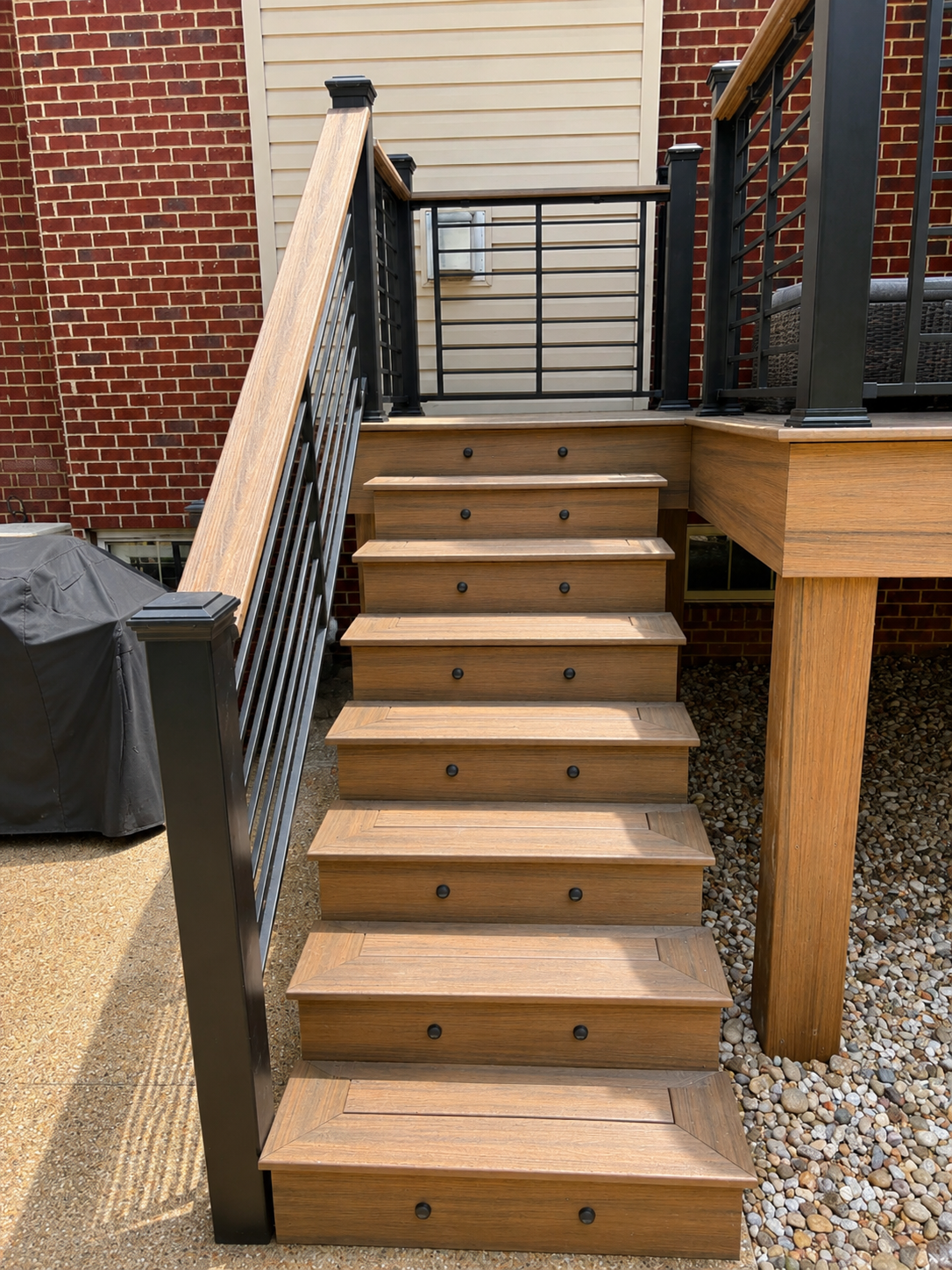 Maintenance Free Oasis Trex deck — close-up of composite stair treads with built-in step lights and black metal railing by Luxe Built Pewee Valley KY