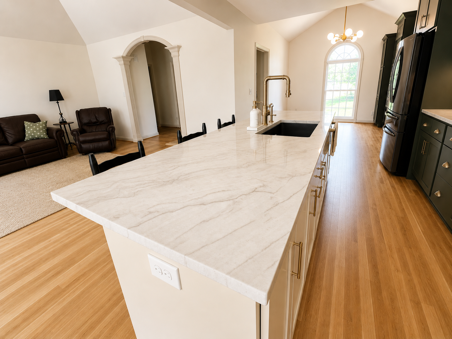 Open Concept Kitchen remodel — marble island close-up with brass faucet, undermount sink, and open living room beyond by Luxe Built Louisville KY