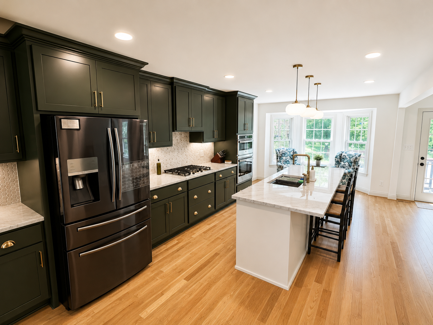 Open Concept Kitchen remodel — dark cabinetry, black stainless refrigerator, white marble island, and bay window seating by Luxe Built Louisville KY