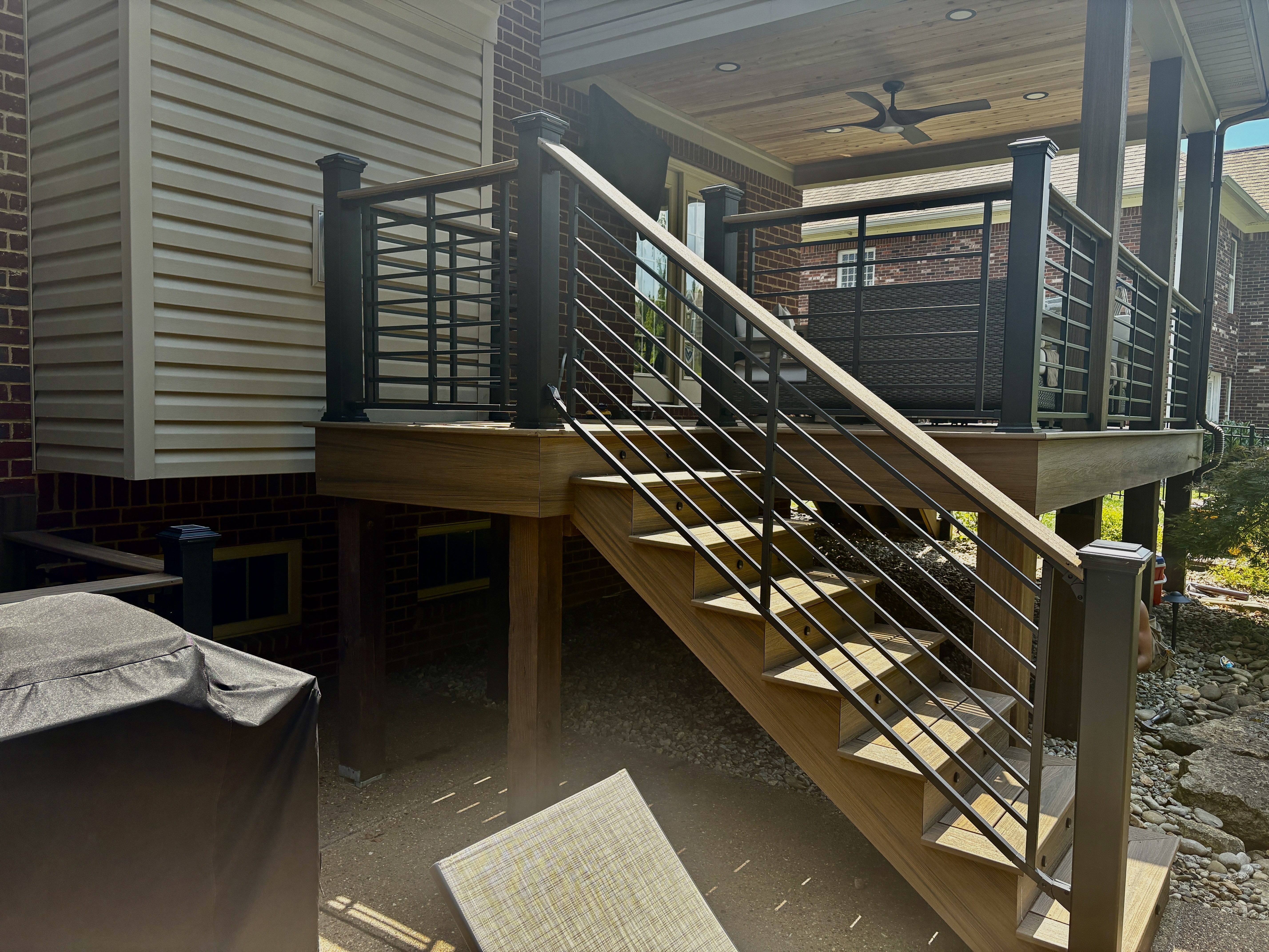 Maintenance Free Oasis Trex deck — staircase with horizontal metal railing, composite steps, and covered porch with ceiling fan by Luxe Built Pewee Valley KY