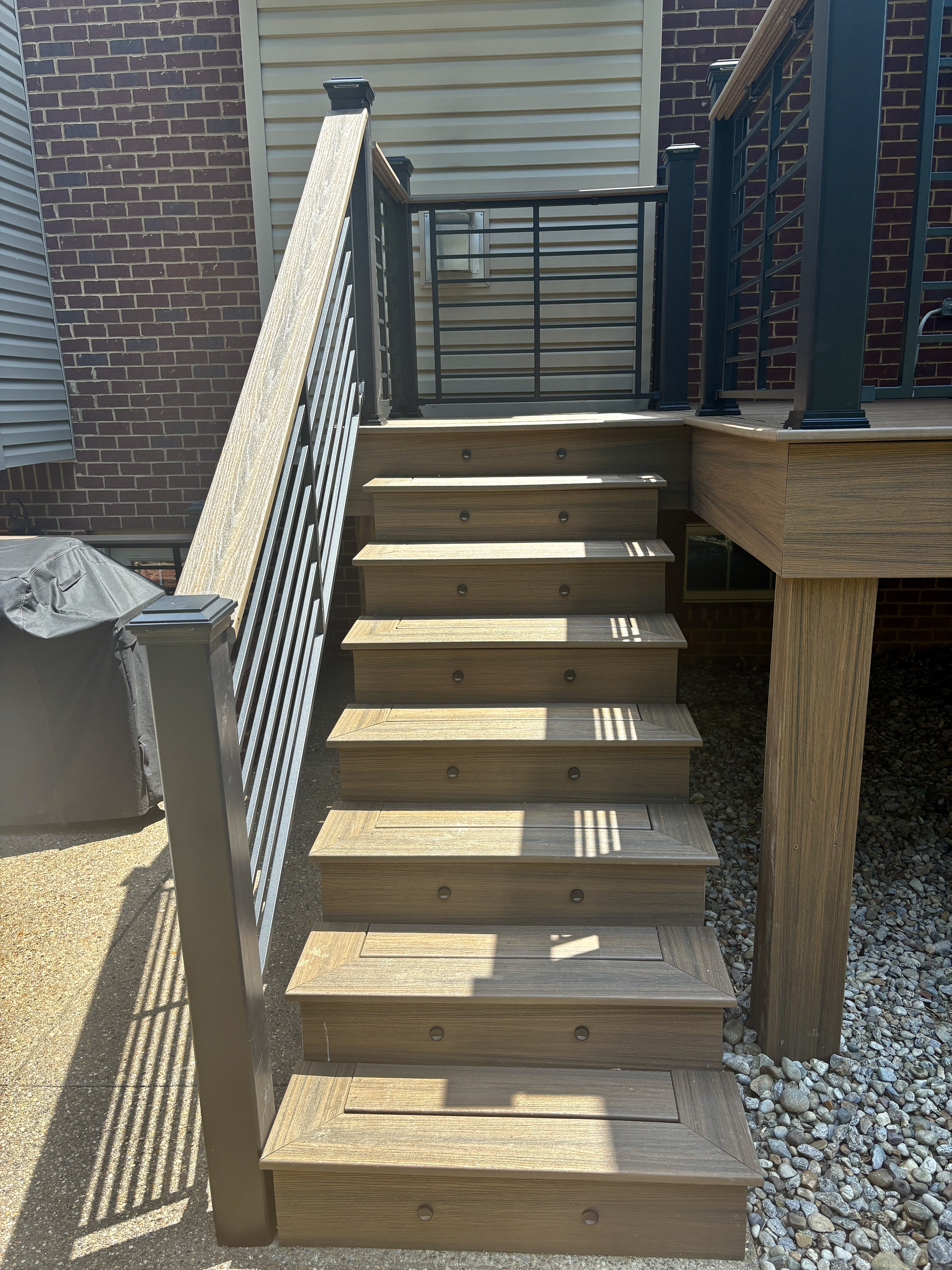 Maintenance Free Oasis Trex deck — close-up of composite stair treads with built-in step lights and black metal railing by Luxe Built Pewee Valley KY