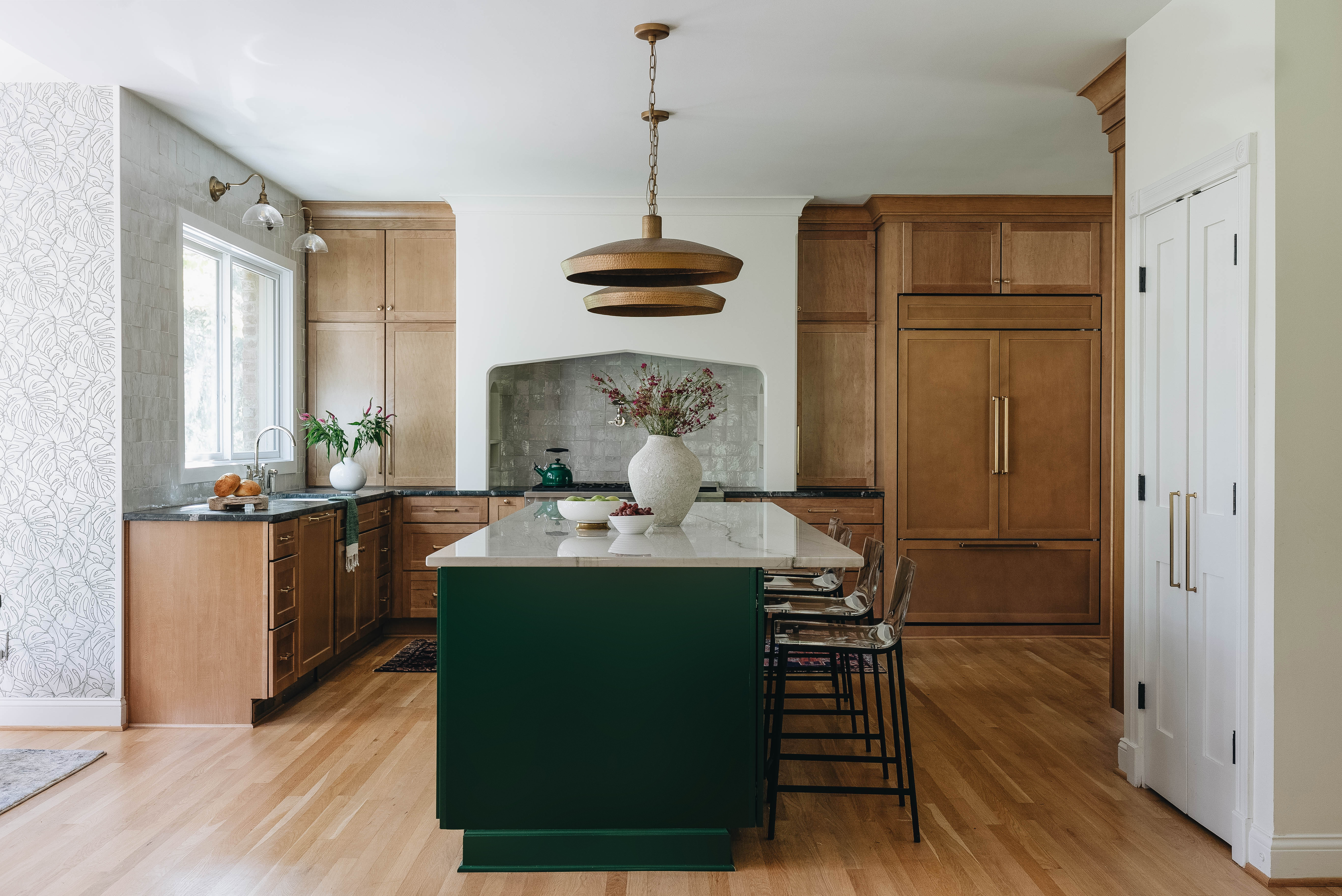 Seneca Gardens kitchen detail — zellige tile backsplash arch over range with custom maple cabinetry and brass fixtures