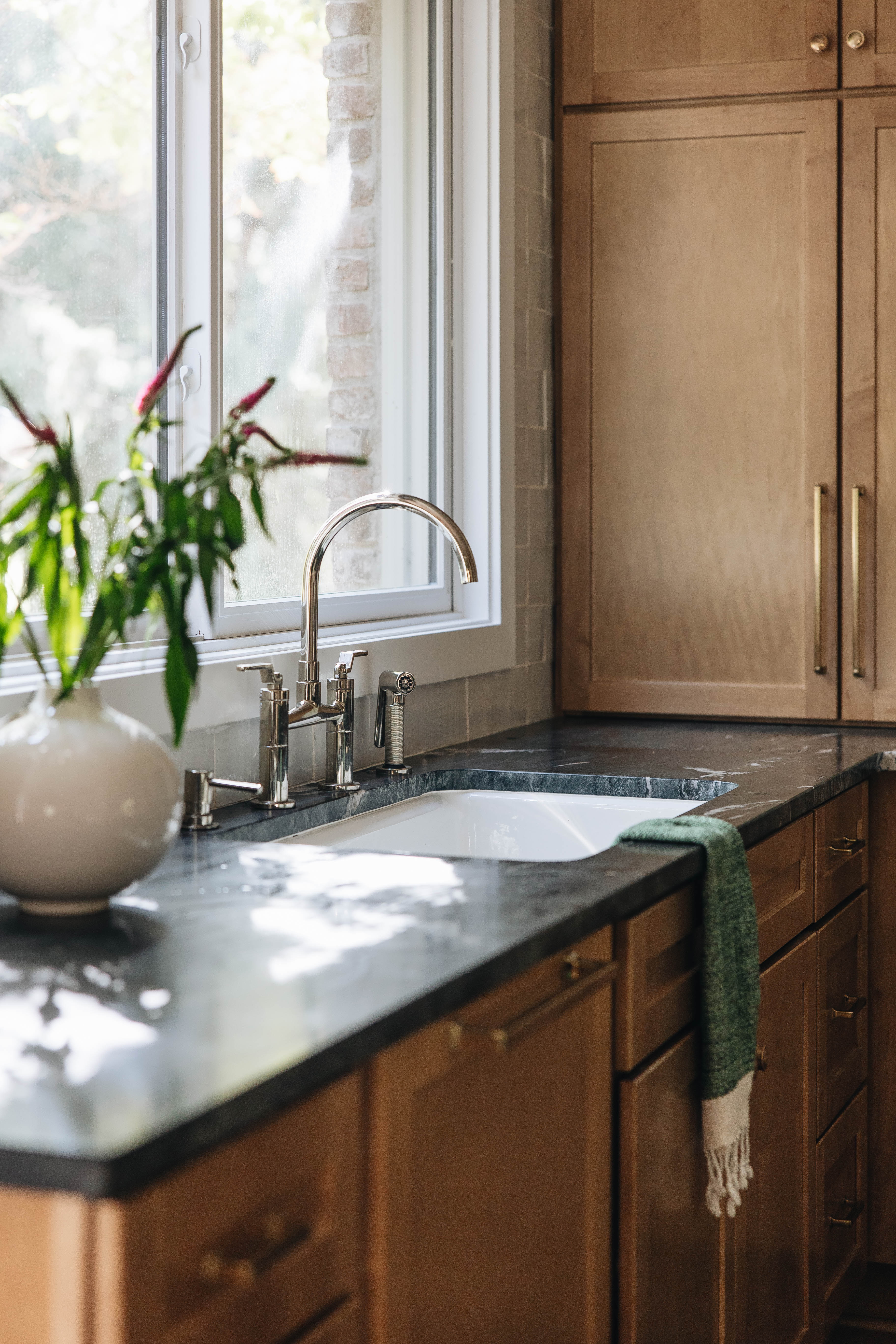 Seneca Gardens kitchen — full view of maple cabinetry, integrated appliances, and brass pendant over island