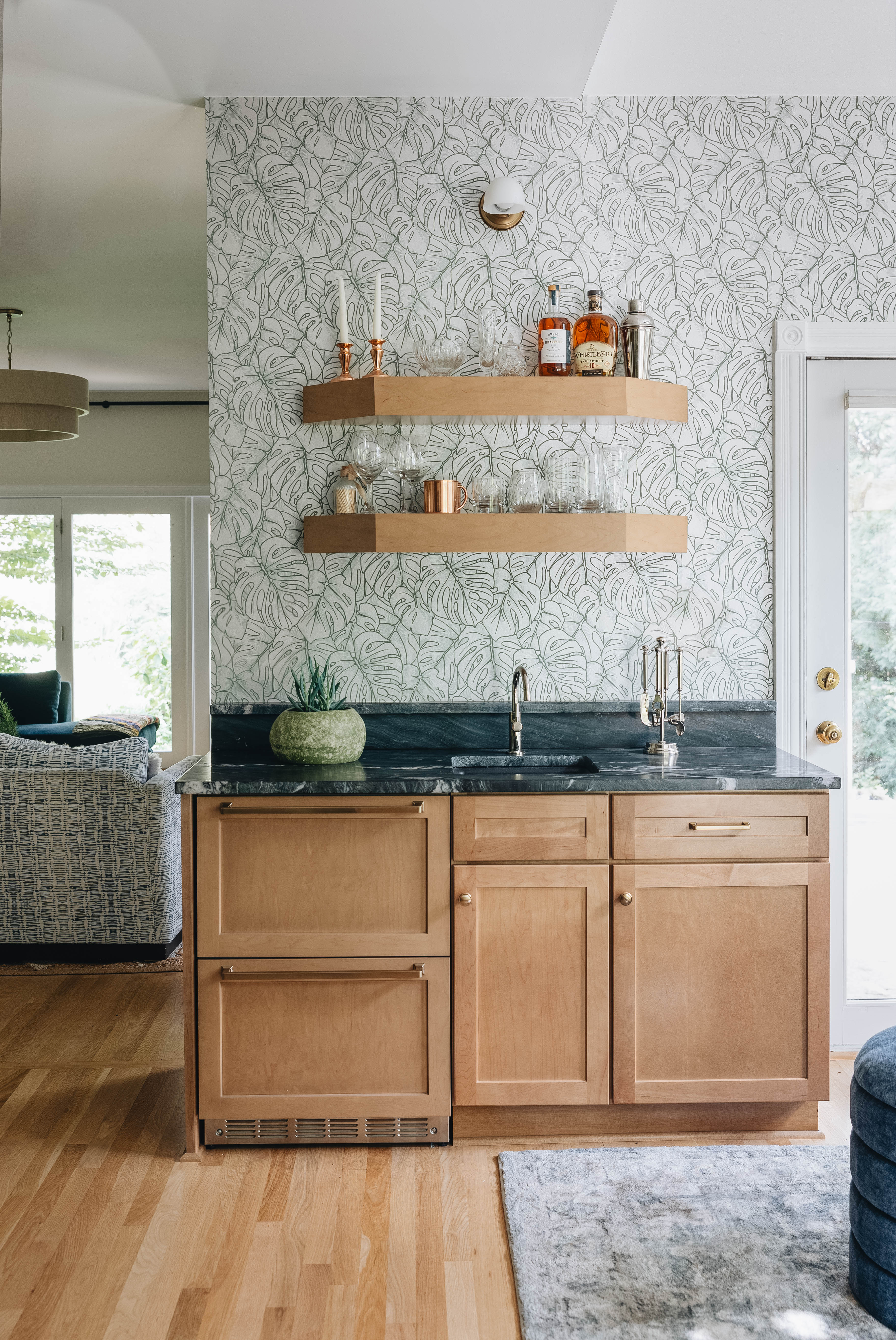 Seneca Gardens living room — custom built-in shelving with grasscloth backing, white shaker cabinets, and fireplace surround by Luxe Built